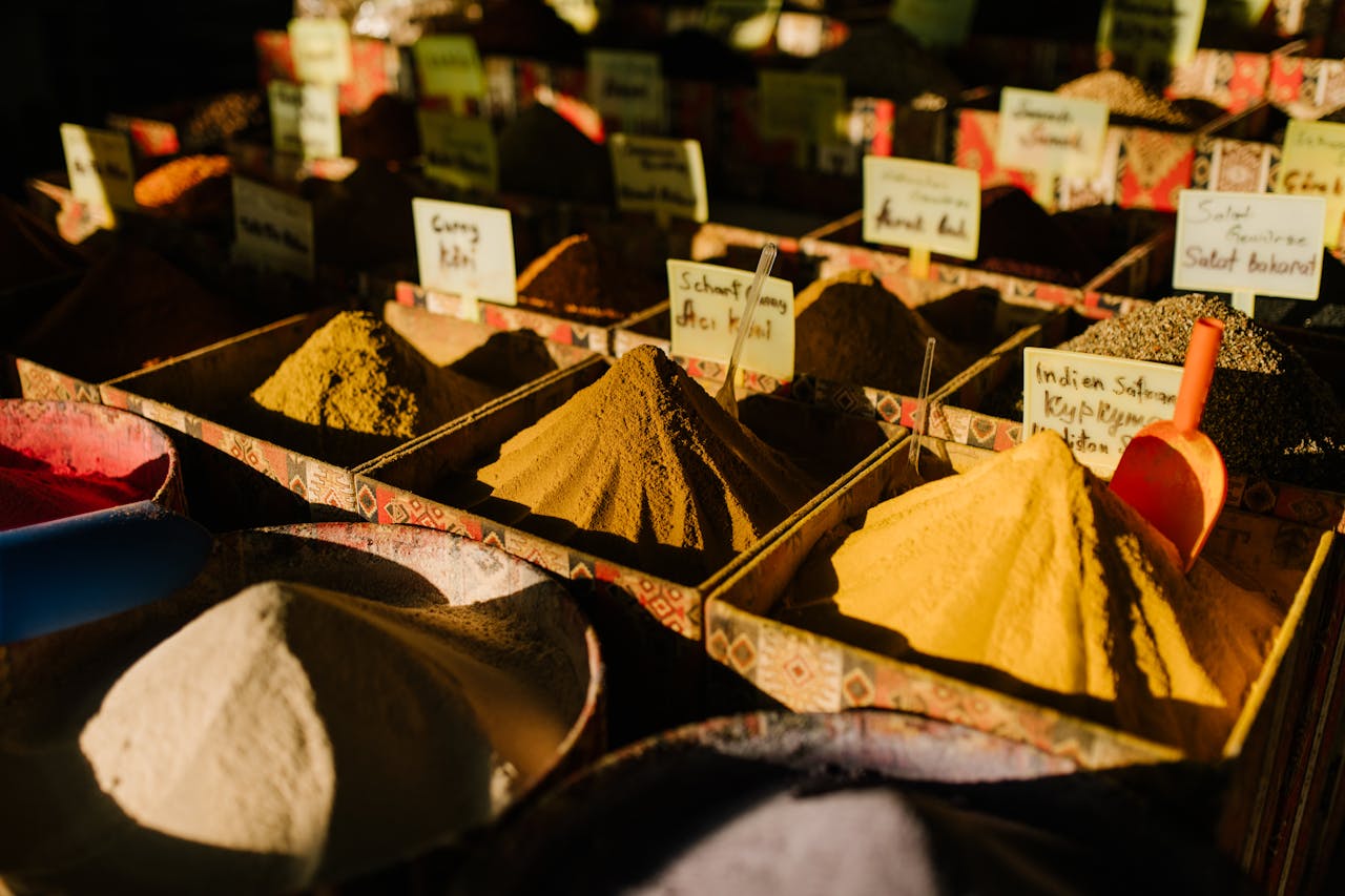 Colorful display of spices in an outdoor market, featuring diverse aromatic and exotic varieties.